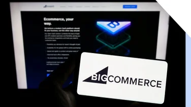 Photo of a laptop screen and phone in front with the BigCommerce logo on the screen