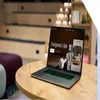 A laptop sitting open on a table in an office, with a Squarespace page open on-screen with the text "Designed to Sell"
