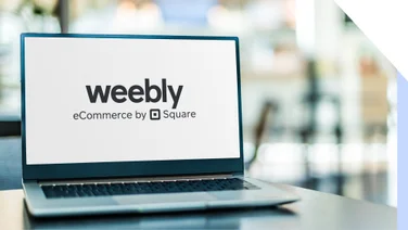 Laptop sits on table showing the Weebly logo