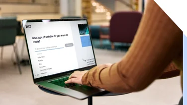 Person choosing a website category on a laptop featuring a Wix's website builder interface.