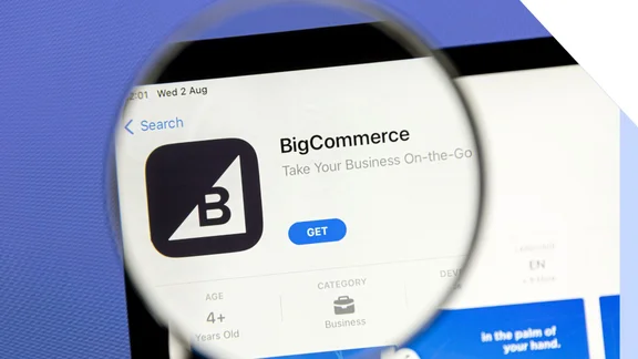 magnifying glass held over laptop screen showing BigCommerce on the app store