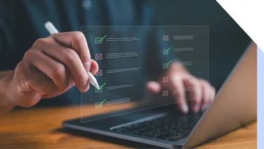 Businessman working on laptop computer comparing checklists