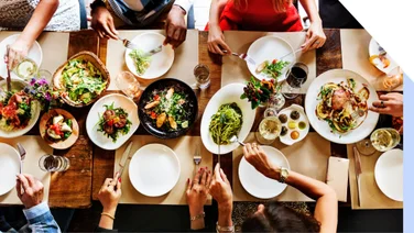 Group eat around a table covered with plates of food