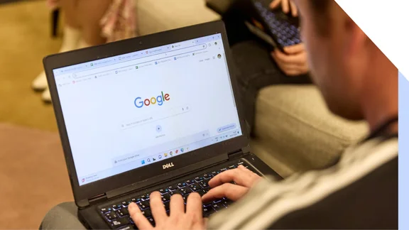 A man uses Google search on his laptop