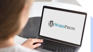Woman looks at WordPress logo on her laptop
