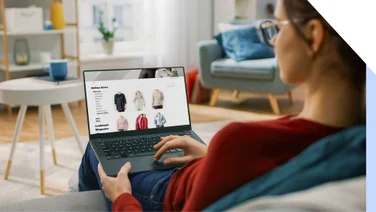 Screenshot of a woman with a laptop on her lap looking at an ecommerce store.