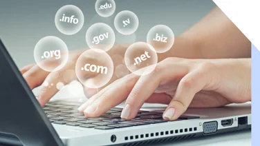 Woman's hands typing at a laptop with clear bubbles floating above showing different domain name extensions