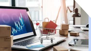 A laptop with a small on trolley with shopping bags on the keyboard.