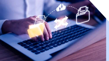 Person types on keyboard with graphics of file sharing floating above the laptop