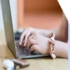 Close-up of a woman's hands typing on a laptop keyboard, showcasing productivity and technology use.