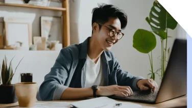 Man smiling while using laptop