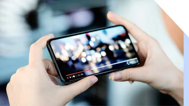 Hands holding a smartphone with a video playing on screen