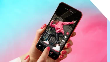 Phone shows a short-form video on social media