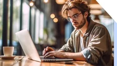 Man sits at a desk working on his laptop