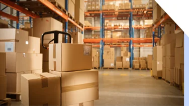 Boxes on a trolley in a warehouse fulfillment center with shelves in the background