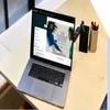 An open laptop on a wooden desk displaying a trendy online fashion store being edited in the Shopify interface.