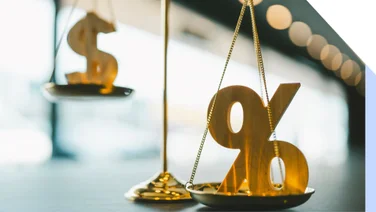 A percentage sign and a dollar sign on gold scales
