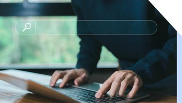 A man typing on a keyboard with an overlay graphic of a search bar on top