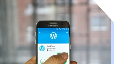 WordPress app shows on a phone with a thumb tapping over it