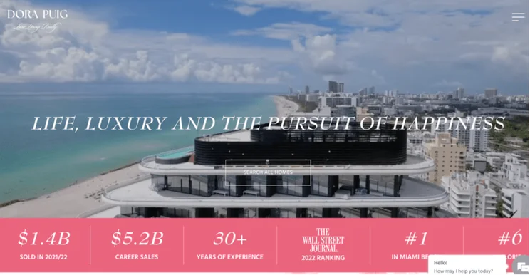 Luxury real estate homepage for Dora Puig featuring a coastal view, with a motto "Life, Luxury and the Pursuit of Happiness," and key achievements.