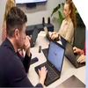 Man looks thoughtfully at the Google search on his laptop screen, as part of a business meeting with colleagues in an office.