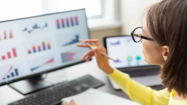 woman with glasess looking at data on screen