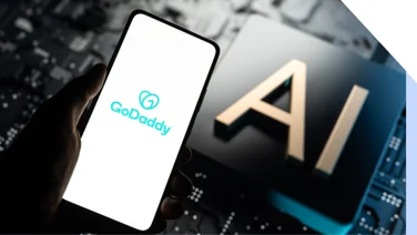 Mobile phone with GoDaddy logo displayed, held above an image that says "AI"