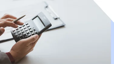 Hands using a calculator against a white backdrop
