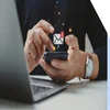 Person holding a mobile phone with a symbol for a new email floating above the device
