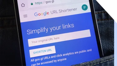 Phone in pocket showing the Google URL Shortener tool homepage