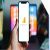 Hand holding a mobile device with the Google Analytics logo on the screen