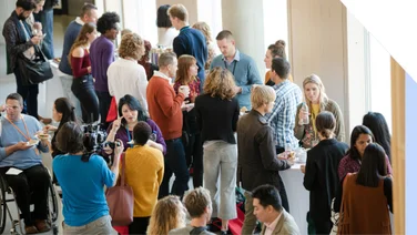 Event space full of a crowd of people networking and talking