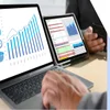 Photo of a laptop and a tablet with graph data on the screen