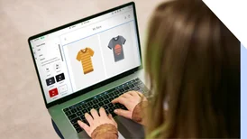 Person using an online store builder on her laptop to customize her t-shirt products on her ecommerce store