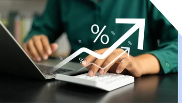 person using a laptop and calculator with a graphic indicating rising profits