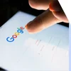 Person tapping a tablet device with the Google homepage on screen
