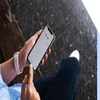 person using Google on phone while sat on a bench