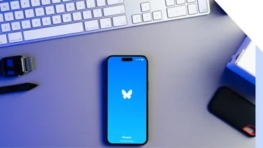 Mobile on a desk showing the Bluesky logo