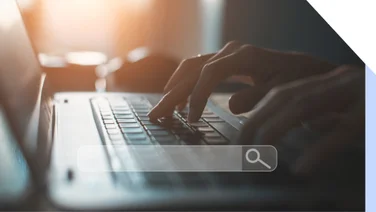 Hands typing at a laptop with a floating image of a search bar on top