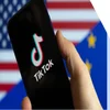 Phone with TikTok logo on the screen being held in front of an American flag
