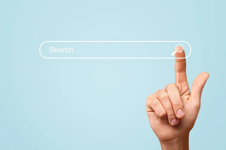 hand pointing to a search bar on a blue background