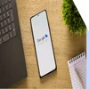 phone on brown table with merchant center logo on