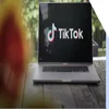 laptop on table outdoors with tiktok logo on screen