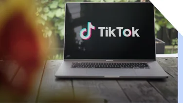 laptop on table outdoors with tiktok logo on screen