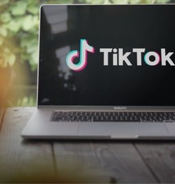 laptop on table outdoors with tiktok logo on screen
