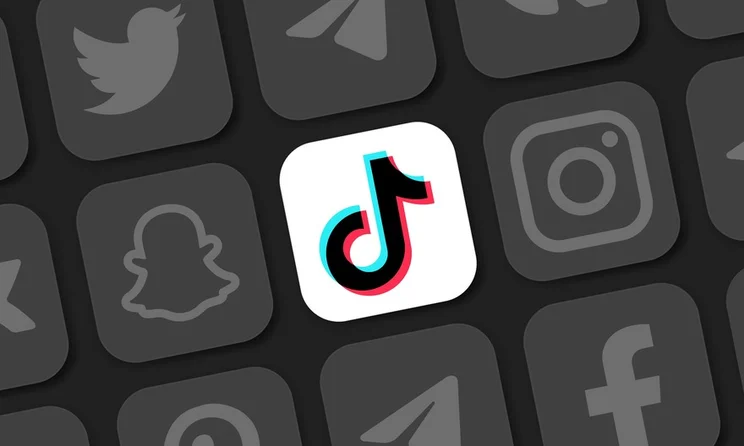 Different social media logos in black and white with the TikTok logo in colour at the centre