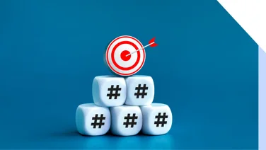 Photo is dice stacked into a pyramid shape with a red target at the top