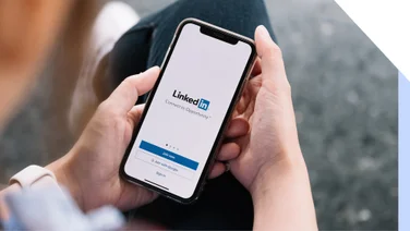 Person holding a phone with the LinkedIn sign up page on the screen