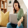 Woman looking puzzled with her hand against her head as she stares at a laptop