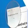 Magnifying glass hovering over a browser showing the Google Business Profile homepage